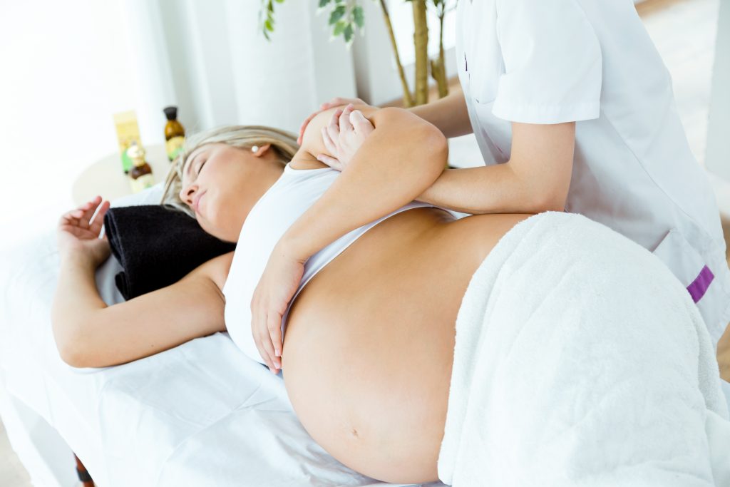 Pregnant woman relaxed while preparing to receive a prenatal massage